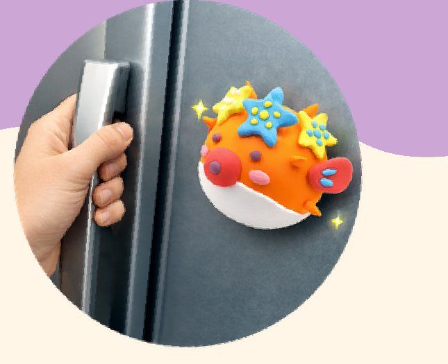 A finished clay pufferfish magnet on a fridge
